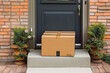 Expedited delivery box outside of front door. Delivered cardboard box package in front of door. Generative AI