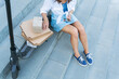 © Artsaba Family - A young girl is sitting on the stairs near her scooter and a lot of boxes she took from the post office. The concept of delivery, ordering from online stores.