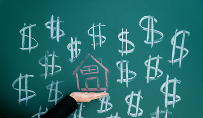 Drawing money and house on blackboard