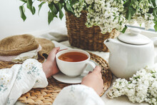 A Cup Of Tea In Hands On A Background Of Lilac, Top View, Aesthetic Photo