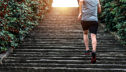 Wall Mural - Low section of runner athlete running on staircase