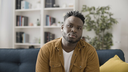 Portrait of a confident and sincere African American man sitting on a sofa at home