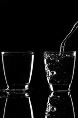 Poster - A glass of water is pouring into two glasses.