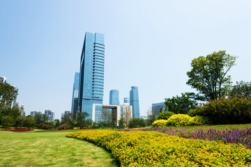 Canvas Print - Green park next to business center buildings