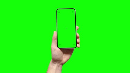 Wall Mural - a man is holding a smartphone with a blank green screen featuring tracking marks, and he is touching