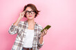 Portrait of thoughtful clever business lady wear plaid shirt smartphone looking interface new website options isolated on pink background