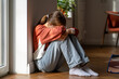 Depression in teens. Upset teenage girl sitting alone on floor and crying, feeling sad and depressed. Lonely teenager child having thoughts of suicide. Mental health of adolescents