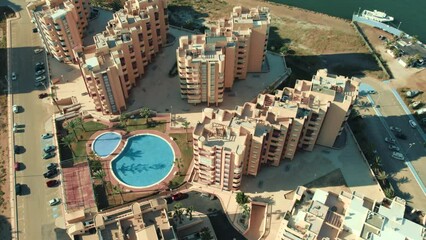 Poster - Aerial shot, drone point of view of La Manga del Mar Menor residential buildings exterior and swimming pool during sunny summer day. Travel and tourism concept. Murcia, Costa Calida. Spain