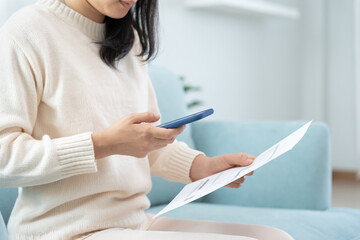 Modern woman use phone to scan barcode or QR codes to pay credit card bill after receive document invoice. payment, receive, paying electricity, digital payments without money, technology, scanning