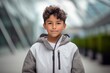 Medium shot portrait photography of a glad kid male wearing a lightweight windbreaker against a modern architecture background. With generative AI technology