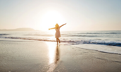 Young woman having fun walking on seaside.