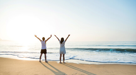 Poster - Young couple embracing enjoying ocean on beach.