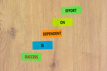 Wall Mural - Success and effort symbol. Concept words Success is dependent on effort on colored paper. Beautiful wooden table wooden background. Business success and effort concept. Copy space.