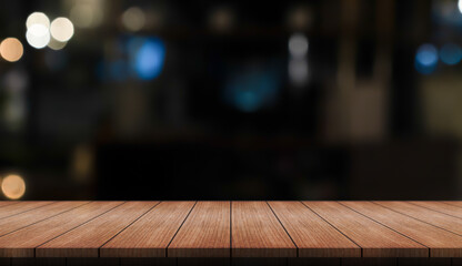 Empty wooden table top with lights bokeh on blur restaurant background.	