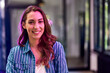 © bnenin - Portrait of a smiling businesswoman dressed in a striped shirt at the workplace.