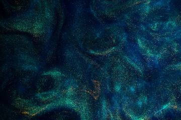 Wall Mural - bursting gold dust particles in blue liquid. abstract gold sparkling particles in blue fluid with gr