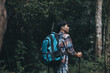 © Charnchai saeheng - Hikers use trekking pole with backpacks and hold tent bag walking through the forest. hiking and adventure concept.