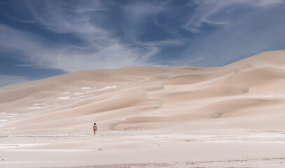 Woman walking outdoors on a sand dune.