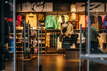 Darkened interior of sports retail store, clothes and shoes, accessories for active lifestyle, abstract background