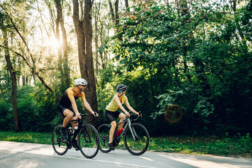 Wall Mural - Couple riding bicycles outside of the city and wearing helmets and sunglasses