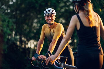 Wall Mural - Couple taking a break from riding bikes outside of the city during a sunset