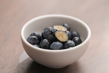 Wall Mural - Fresh blueberries in white bowl one berry is cut in halves