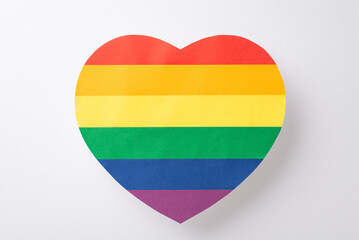 A top-down perspective of symbol for LGBT support, such as large rainbow colored heart shaped postcard, placed on a white background with a blank space for text or ads