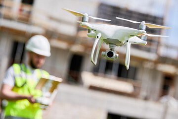 Wall Mural - drone operated by safety engineering inspector. construction worker piloting drone on building site