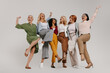 © gstockstudio - Multi-ethnic group of happy mature women embracing and dancing against grey background