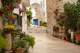 Fototapeta Kwiaty - one of the charming narrow street decorated with flowers of picturesque Monopoli old town, Puglia, Italy