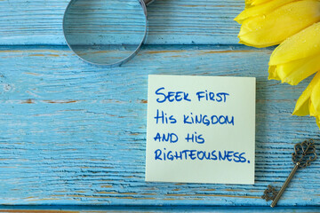 Wall Mural - Seek first His kingdom and righteousness, handwritten biblical verse on note with ancient key, magnifying glass, and yellow tulips on wood. Top view. Christian change, growth, obedience to God concept