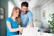 © BillionPhotos.com - Two cheerful office workers work with laptop,
