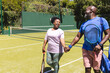 © WavebreakMediaMicro - Happy senior african american couple with rackets walking holding hands on sunny grass tennis court