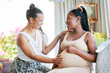© Nicholas Felix/peopleimages.com - Pregnant, friends and woman touching a stomach, baby shower and excited with happiness, home and support. Female people, girls and lady feeling belly, pregnancy and event with celebration and party