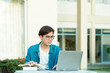© ijeab - Student studying outdoor using laptop.