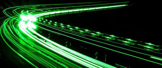 Wall Mural - green lines of car lights on black background