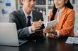 © laddawan - Business documents on office table with smart phone and calculator digital tablet and graph business with social network diagram and two colleagues discussing data working