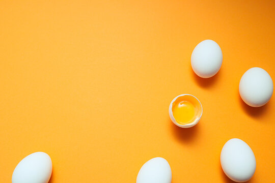 White eggs and egg yolk on the yellow background.