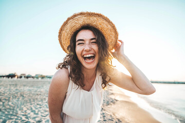 happy beautiful young woman smiling at the beach side - delightful girl enjoying sunny day out - hea