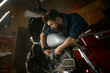© Nomad_Soul - Male mechanic working in garage and repairing custom motorcycle