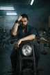 © Nomad_Soul - Portrait of brutal man mechanic sitting on repaired motorcycle