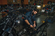 © Nomad_Soul - Background of motorcycle workshop with auto mechanic resting during break time
