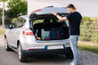 © Aleksandr - Side view of handsome man close hatchback car for trunk. Vehicle and automotive travel road trip. Holliday on summer vacation concept
