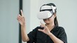 © M Stocker - Young women wearing VR goggles posing finger touching on the air. Woman testing VR glasses or goggles working with virtual reality. Metaverse technology concept