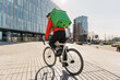 © muse studio - A male cyclist in a helmet riding a bicycle ecotransport to work with a bag.  The courier is a guy with a thermos, delivering lunch and groceries from the store to the house.