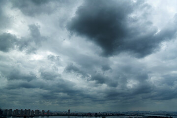 Wall Mural - dark clouds over a city by the sea