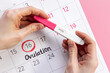 Pregnancy test with female ovulation day on calendar