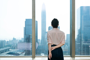 Wall Mural - Businesswoman standing in front of the window