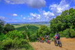 Unrecognisable mountain bikers ride on a firebreak trail over the beautiful landscape with its hills in Tuscany, Massa Marittima, Italy