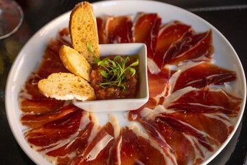 Canvas Print - Jamon plate with crosinis on a restaurant table